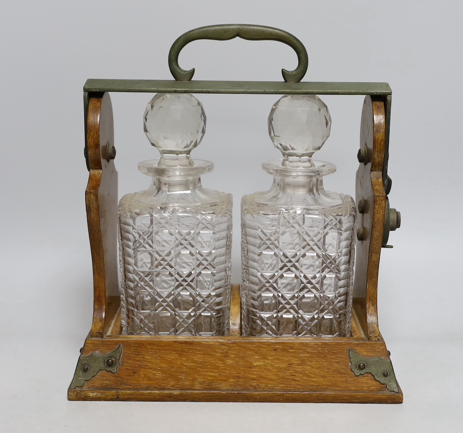 An Edwardian Betjemann’s Patent two bottle oak tantalus, 17cms wide